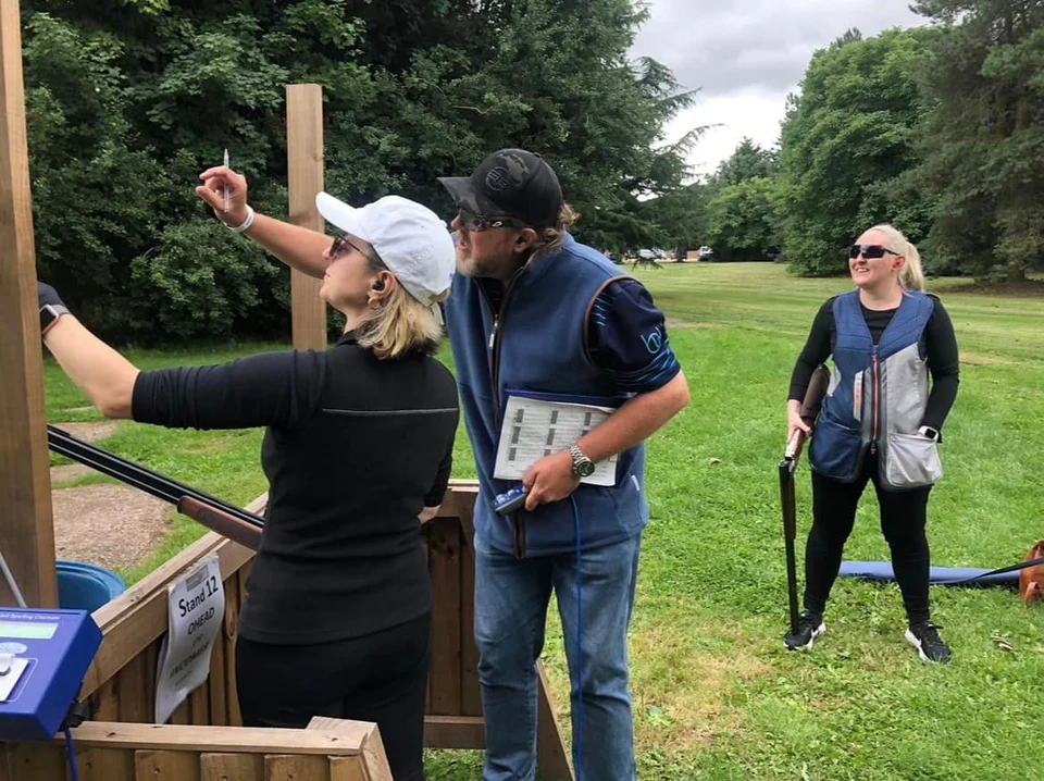 BW Clay Shooting - Brent - our expert shooting instructor -giving lessons to a female client in a white hat.