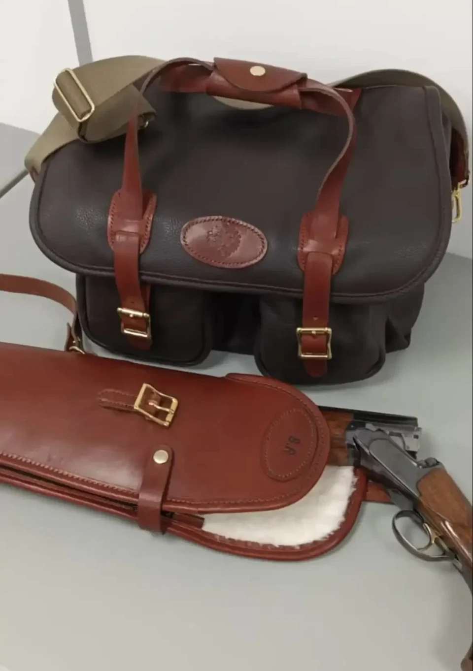 Black leather bag and brown gun slip.