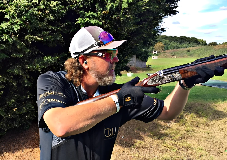 Brent Woodard aiming his shotgun at a clay target.