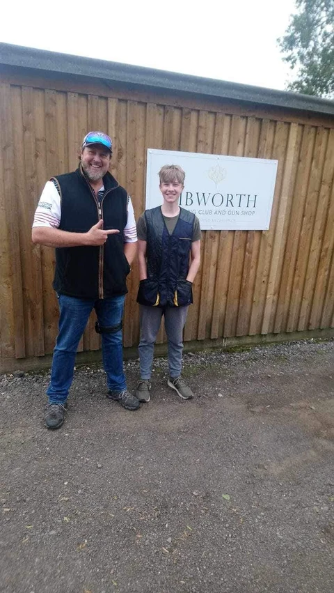 Brent Woodard with a young clay shooter outside the shooting clubhouse.