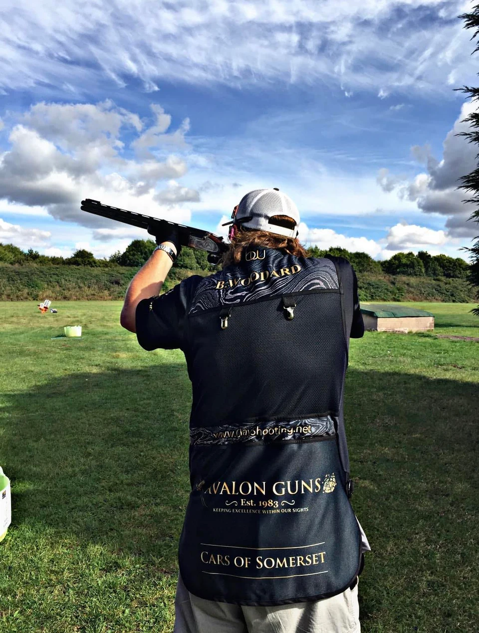 Brent Woodard shooting a clay target, viewed from behind.