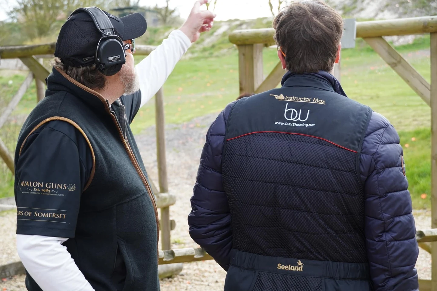 An instructor and shooter reviewing a target at the clay ground.