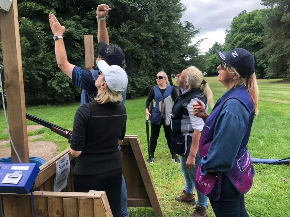 An instructor demonstrating a target line to a group of shooters.